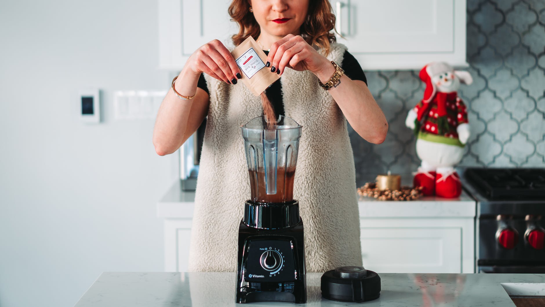 womna pouring powder on the blender