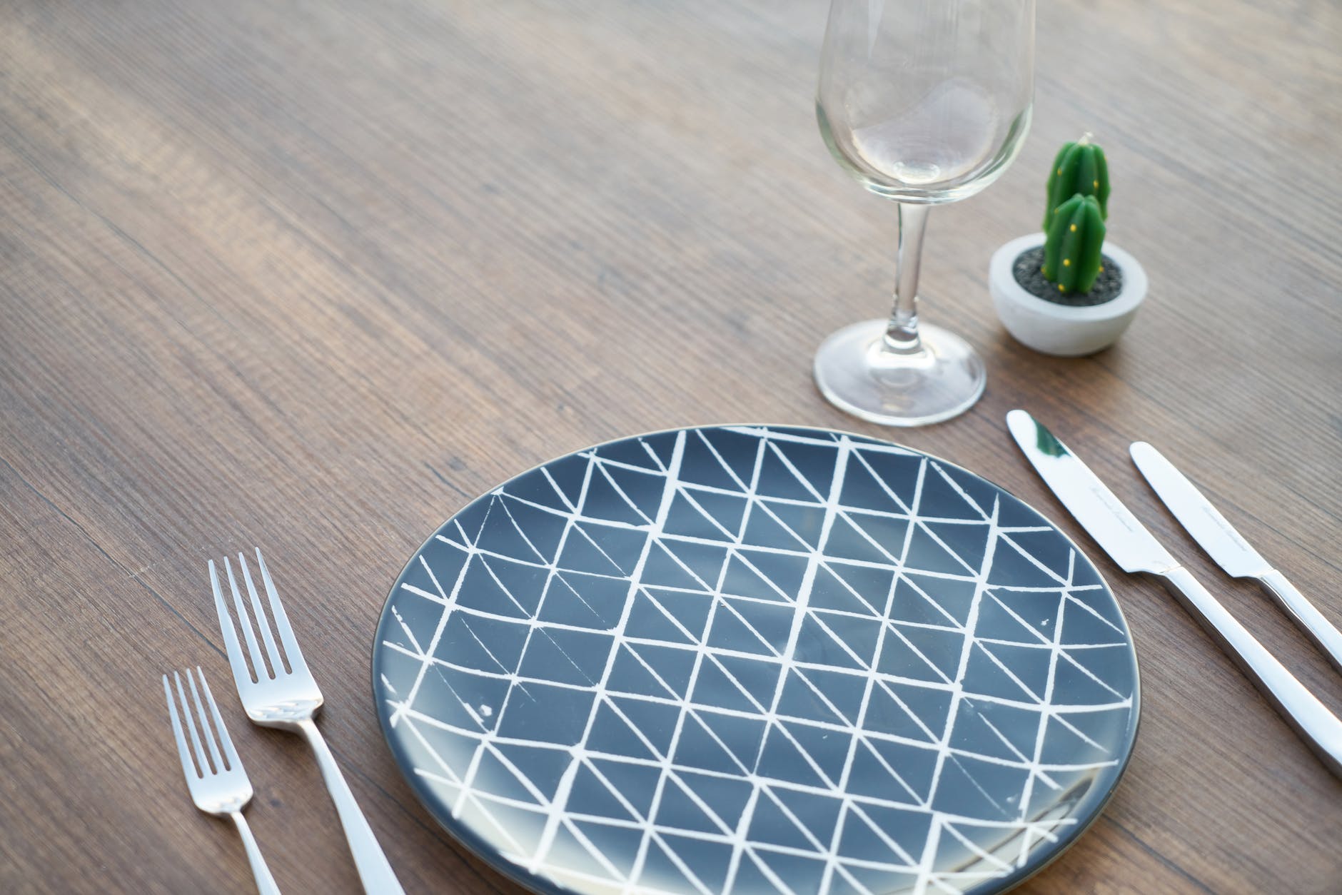 round blue and white ceramic plate two forks two knives and wine glass