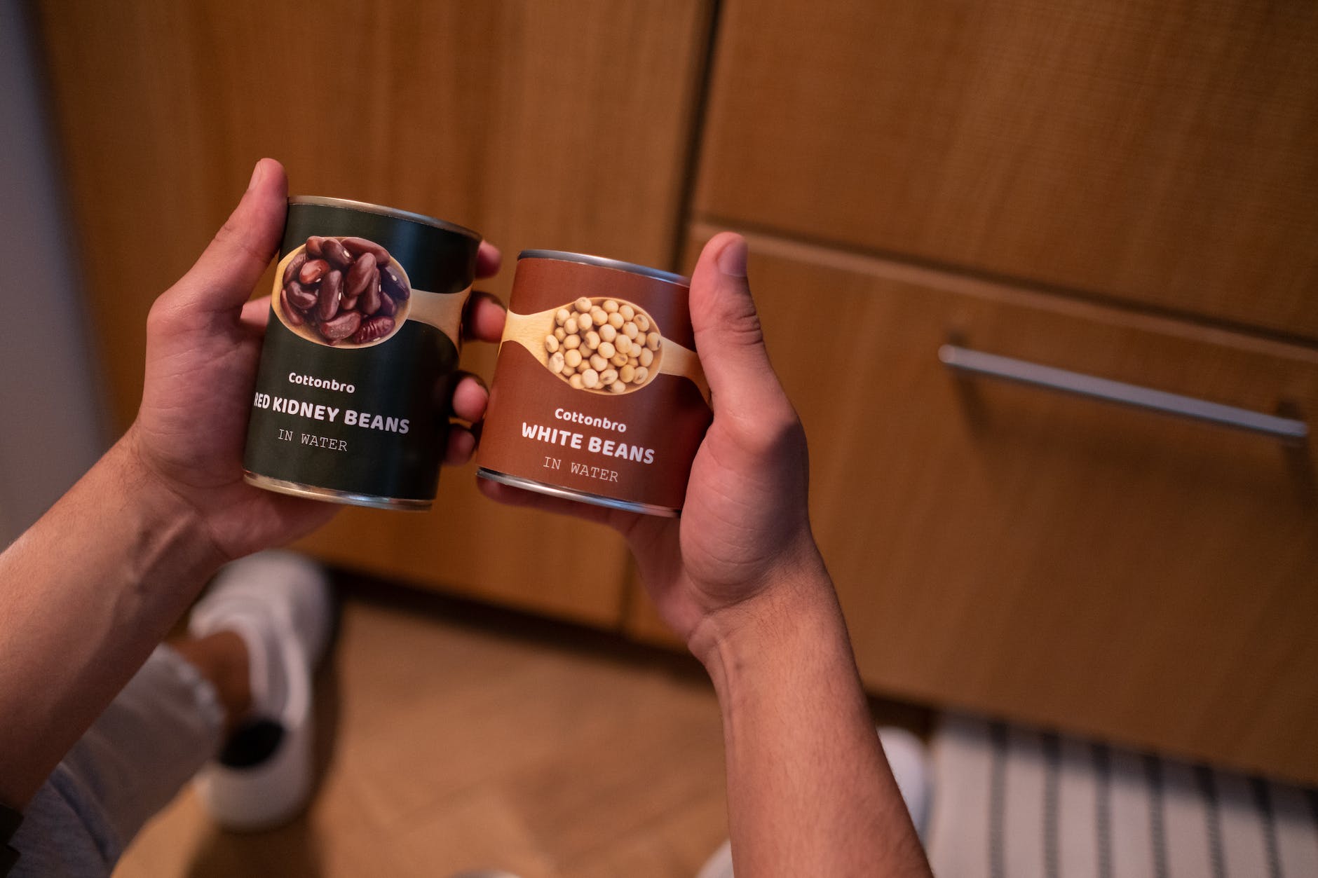 hands of a person holding tin canned food