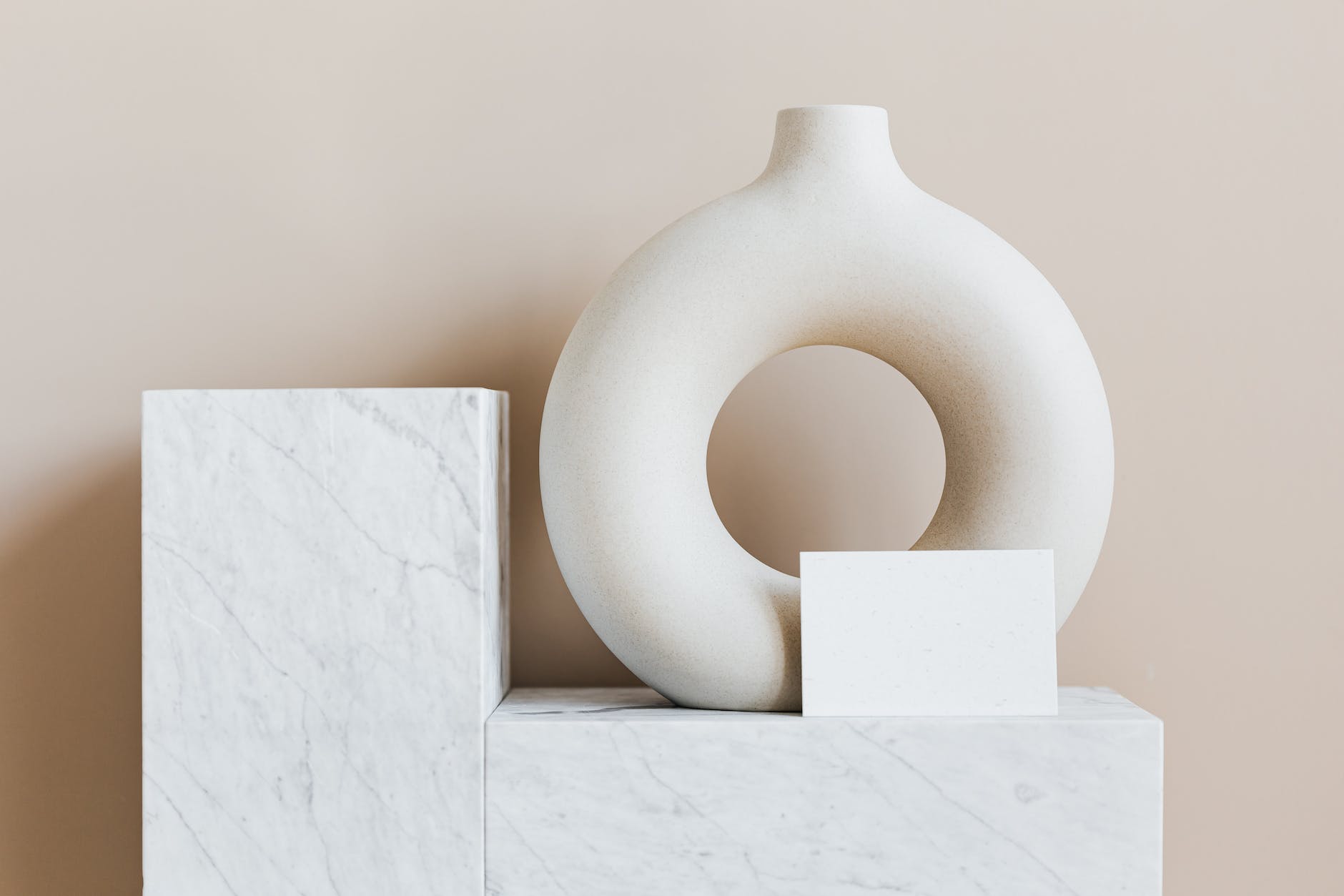 decorative vase of ring shape with blank card on marble stand